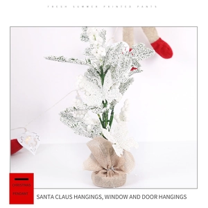Miniature snow-flocked Christmas tree with natural burlap base for office desk decor