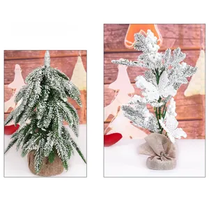 Close-up of snow-flocked mini Christmas trees with rustic burlap-wrapped bases