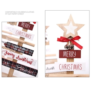 Detail of wooden Christmas tree decor with red bow, metal bell and festive carvings