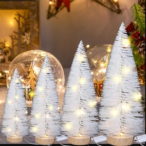 Détail de quatre mini sapins de Noël LED blancs avec lumière chaude et socles en bois