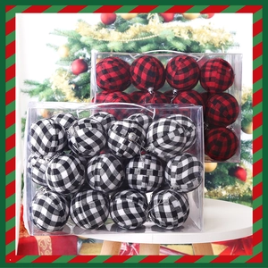 Detail of red and black plaid Christmas balls in clear gift boxes on a holiday table