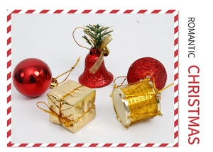 Close-up of red and gold Christmas ornaments set featuring bells, gift boxes and drums