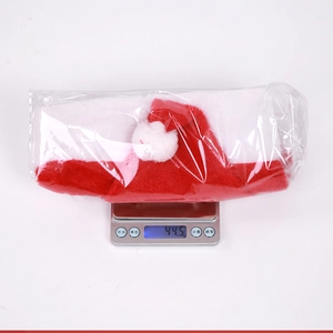 Detailweergave van een pluche kerstmuts met pompon in verpakking met gewicht van 44,5g