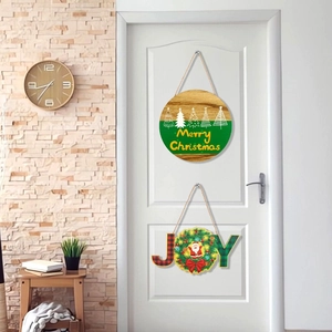 Detail of wooden Merry Christmas sign and JOY wreath hanger on a white room door