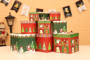 Detalle de cajas de regalo de Navidad apiladas con dibujos de Papá Noel y muñecos de nieve