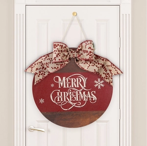 Detail of red and brown wooden Merry Christmas door sign with a large red berry bow