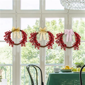 Three Christmas red berry wreaths with festive striped bows hanging on a white window