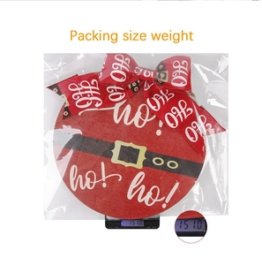 Detailed view of Christmas Santa door sign on scale showing 151g weight and red ribbon bow
