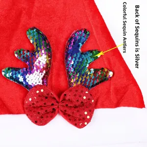 Dettaglio di corna di renna con paillettes colorate e fiocco rosso su cappello di Natale