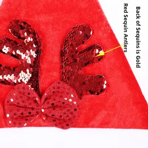 Dettaglio delle corna di renna con paillettes rosse su cappello di Natale e retro oro