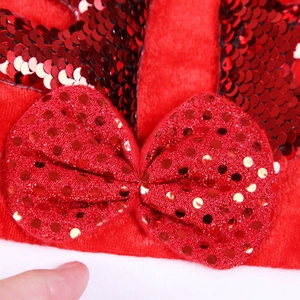 Dettaglio ravvicinato di un fiocco con paillettes rosse e velluto per fascia di Natale