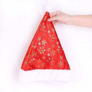 Detail view of red velvet Santa hat featuring gold snowflake prints and white plush trim