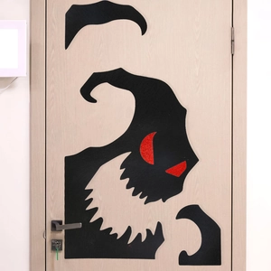 Detail of black felt Halloween monster door sticker featuring red glitter eyes for decor