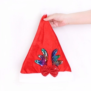 Dettaglio del cappello di Natale in velluto rosso con corna di paillettes colorate