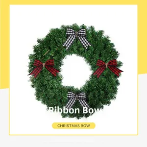 Close-up of red and black plaid Christmas ribbon bows on a green decorative wreath