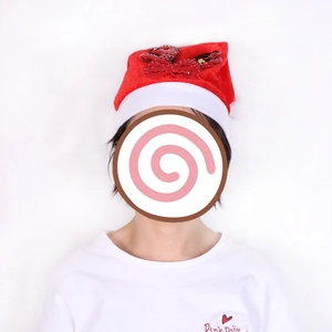 Dettaglio cappello di Natale in velluto rosso con fiocco di paillettes e bordo in peluche
