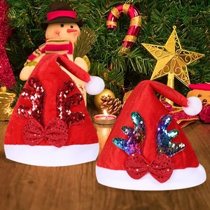 Dettaglio cappelli natalizi in velluto rosso con corna di renna di paillettes e bordo soffice