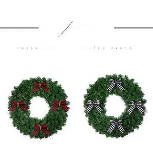 Christmas pine needle wreaths with red, black and white plaid bows for holiday decor