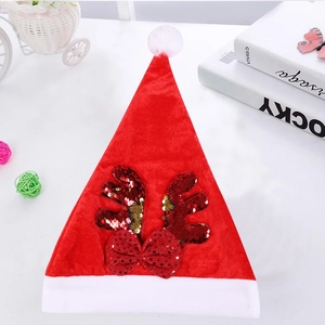 Dettaglio del cappello di Natale rosso con corna di renna di paillettes e pompon di peluche