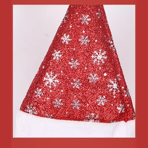 Detailed macro of red sequin Santa hat with silver snowflakes and white plush trim