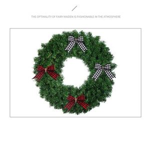 Close-up of green Christmas wreath featuring red and black buffalo plaid fabric bows