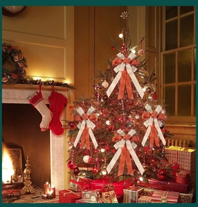 Close-up of dual-layer Christmas bows with orange and beige ribbons on a festive tree