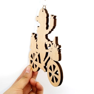 Laser-cut wooden Christmas pendant featuring Santa on a bicycle with tree and gifts