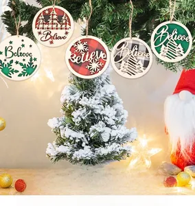 Close-up of wooden hollow Believe ornament with plaid fabric on a Christmas tree branch