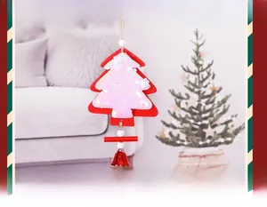 Close-up of glittery Christmas tree ornament with a small red bell and twine loop