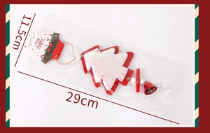 Detail of red wooden Christmas tree ornament with white sequins and a small metal bell