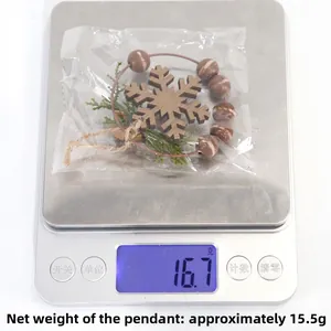 Detail showing Christmas snowflake ornament with pine branches weighing 15.5g on a scale