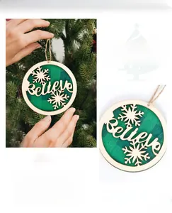 Close-up of wooden Christmas tree ornament with green plaid base and Believe engraving