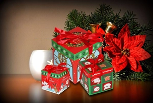 Close-up of three festive nested Christmas gift boxes with ribbons and holiday illustrations