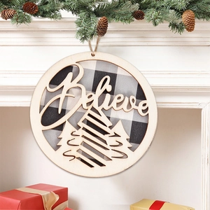 Detail of wooden Believe Christmas ornament with buffalo plaid back on a festive mantel