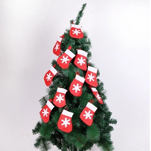 Dettaglio di calze natalizie rosse decorative con fiocchi di neve su albero verde
