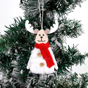 Pendentif renne de Noël avec corps en peluche et écharpe rouge sur un sapin de Noël enneigé