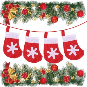Dettaglio di quattro calze di Natale in feltro rosso e bianco con motivi a fiocco