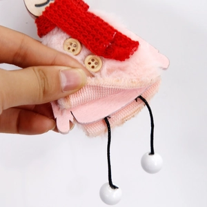 Détail de renne en peluche avec écharpe rouge et boutons en bois pour décor de Noël