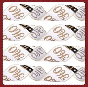 Close-up of white Christmas ribbon with gold edges and fancy H letter pattern printing
