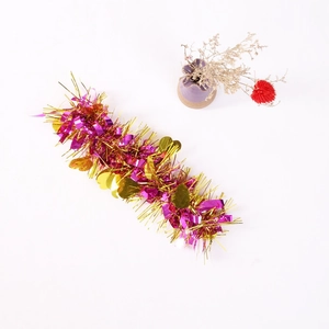 Detail of pink and purple tinsel garland with shiny gold heart-shaped sequins for party