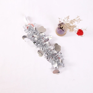 Close-up of metallic tinsel garland with heart sequins for party and holiday decorations