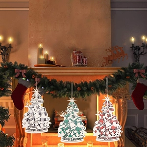Trois ornements de Noël en bois suspendus devant une cheminée chaleureuse au décor festif