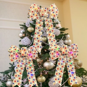 Tre fiocchi di Natale a LED in juta con stelle colorate su un albero di Natale