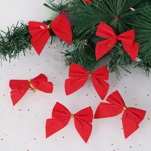 Mini red velvet Christmas bows with gold tie fasteners on a festive pine branch