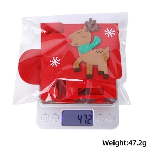 Detailed view of red reindeer Christmas gift bag on scale weighing 47.2g in packaging