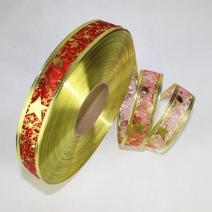 Close-up of 2.5cm Christmas ribbon with gold edges, red stars and musical note patterns