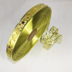 Detail of 2.5cm gold Christmas ribbon with star pattern for gift wrapping and DIY crafts