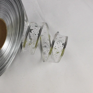 Close-up of 2.5cm silver mesh ribbon with glittery star patterns for Christmas gift wrapping