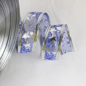 Macro detail of blue Christmas ribbon with silver star patterns and wired edges