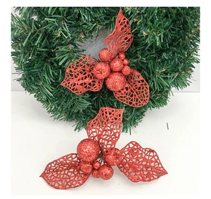 Close-up of red glitter holly berry ornaments with hollow leaves for Christmas tree decor